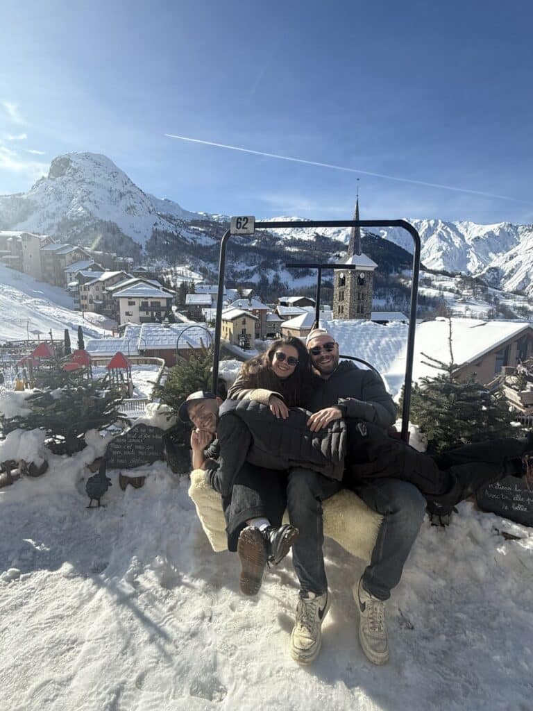 Vincent, Zoé et Maxime, membres de l'équipe du restaurant Le Montagnard, posant ensemble sur un télésiège enneigé à Saint-Martin-de-Belleville